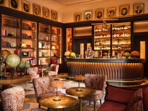 a bar with chairs and a man standing behind the counter at Collegio alla Querce, Auberge Collection in Florence