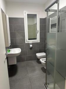 a bathroom with two toilets and a sink and a mirror at BeB e Ristorante Fish Art in Bollate