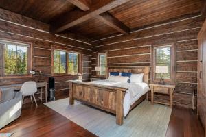 a bedroom with a bed in a room with wooden walls at Big Sky Fire Towers - Two Home Compound - Sleeps 16! in Big Sky