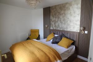 1 dormitorio con 1 cama con sábanas de oro y almohadas en Appartement Luxe Floral Stay 15 Min To CDG And Paris, en Le Bourget