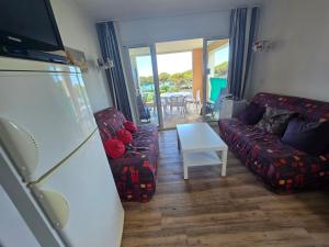 ein Wohnzimmer mit Sofa und Tisch in der Unterkunft Les rives des Issambres 1201 in La Garonnette-Plage