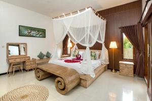 a bedroom with a bed with a canopy at Tamyang Ubud Villas in Ubud +62 photos