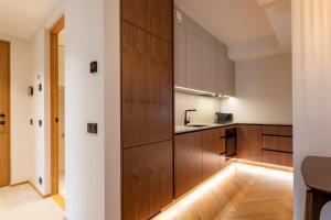 a kitchen with wooden cabinets and a sink at Heven Apartments Karusselli in Pärnu