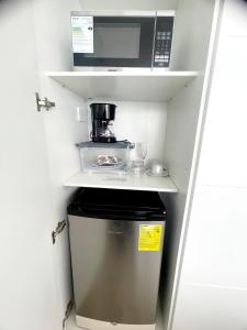 a small refrigerator in a small kitchen with a microwave at Karibao Ecuabook Room Jacuzzi Sea View 7B in Playas