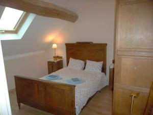 una camera da letto con un letto di legno e una finestra di Les Trois Croix a Santenay