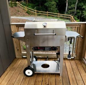 a barbecue grill sitting on a deck on a porch at Unique Rustic Barn Theme home Amazing views! Luxe in Bailey Camp