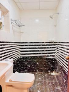 a bathroom with a toilet and a sink at Atrium Hotel By Bestinn Leisure in Bengaluru