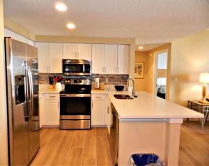 a kitchen with white cabinets and stainless steel appliances at Wyndham Ocean Walk Resort 2332 - Vacation in Comfort and luxury - 2BR Oceanview in Daytona Beach