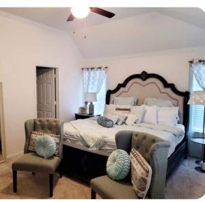 a bedroom with a large bed and two chairs at Catbird Hideaway in Humble
