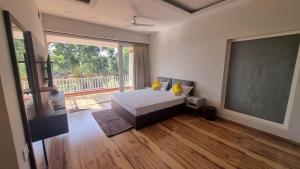 a bedroom with a bed and a large window at Prantik Retreat in Bāgnān