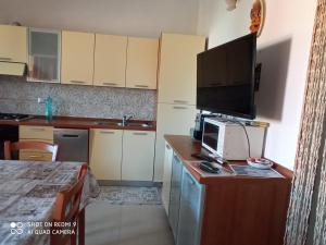 a small kitchen with a tv on a wooden counter at VIA BOCCACCIO 16 in Budoni