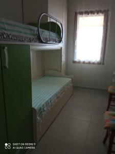 a small room with a bunk bed and a window at VIA BOCCACCIO 16 in Budoni