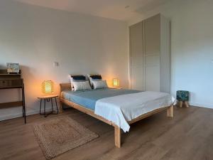 a bedroom with a large bed with two lamps at Retiro do Lago in Ferreira do Zêzere