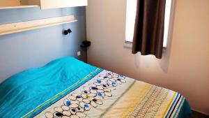 sypialnia z łóżkiem z niebieskim kocem w obiekcie Camping Tikayan Félix de la Bastide w mieście Saint-Mitre-les-Remparts +37 zdjęć