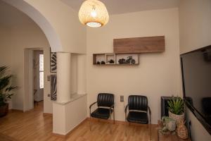a living room with two chairs and a chandelier at Zante Beauty Downtown House in Zakynthos Town