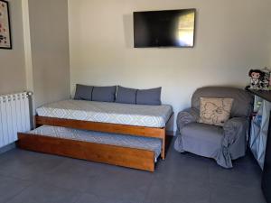 a bed and a chair in a room at Casa da Anita in Juncal +13 photos