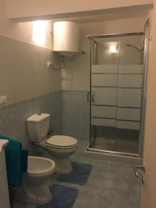 a bathroom with a toilet and a glass shower at Giglio Home in Catania