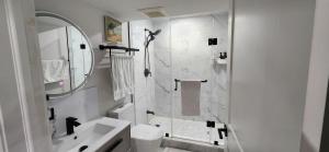 a white bathroom with a shower and a sink at Entire 2 Bedroom Apartment in Kitchener in Kitchener +36 photos