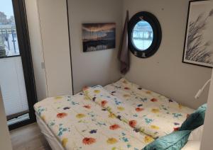 a bed with a comforter on it in a bedroom at Hausboot Fjord Capella - Solarboot in Barth in Barth