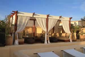 - un salon avec des rideaux et un canapé dans l'établissement Dar Assiya, à Marrakech