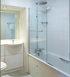 a bathroom with a glass shower and a sink at Craigside Manor in Llandudno