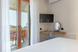 a bedroom with a bed and a tv and a mirror at Villa Angelo in Paleokastritsa