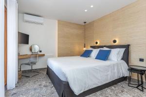 a bedroom with a large bed with blue pillows at Villa Angelo in Paleokastritsa