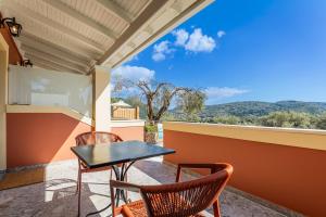 a balcony with a table and chairs and a view at Villa Angelo in Paleokastritsa