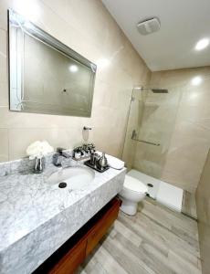 a bathroom with a sink and a shower and a toilet at Karibao Ecusuites Double Room D in Playas
