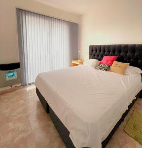a large bed in a bedroom with a large window at Nisen Temporarios in La Plata