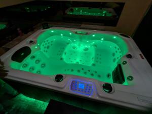 a bath tub with a green top in a room at Grande maison proche Carcassonne 10 p piscine spa sauna Le Grand Chalet Bellevue in Cavanac