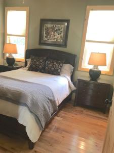 a bedroom with a bed with two lamps and two windows at Ridgecrest A Unique Rustic Cabin in Blowing Rock NC in Bailey Camp +41 photos