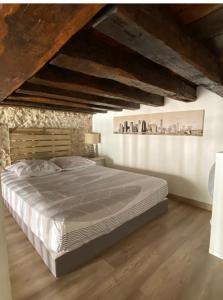 una camera da letto con un letto grande e pavimenti in legno di Studio-mezzanine en centre ville proche Cathédrale a Orléans