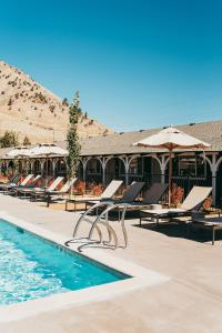 a pool with chairs and umbrellas next to a building at The Virginian Lodge in Jackson