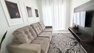 a living room with a couch and a television at Apartamento 3 min FIP e StopShop in Brusque