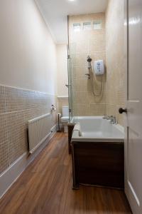 a bathroom with a bath tub and a toilet at Station Road Stays in Kirk of Shotts