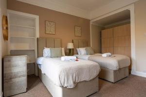 a bedroom with two beds with white sheets at Station Road Stays in Kirk of Shotts +31 photos