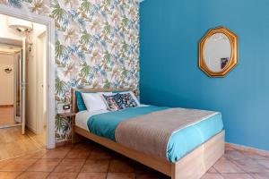 een slaapkamer met een bed en een blauwe muur bij Sabbie dell'Etna - Eleganza e Comfort nel Cuore di Catania con Parcheggio Privato in Catania