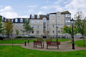 a park with benches in front of a large building at Fonthill Apartment - central, free parking off street in Aberdeen