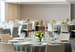 a conference room with tables and chairs with glasses and flowers at NH Collection México City Centro Histórico in Mexico City