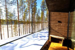 a sauna in a forest with snow on the ground at Hossaville Luxe Lake Cabin in Hossa