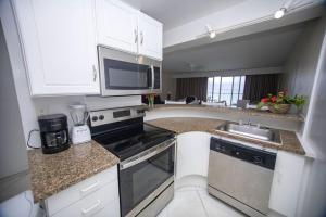 a kitchen with white cabinets and a stove top oven at Villa les pieds dans l'eau à Saint-Martin in Cupecoy +8 photos