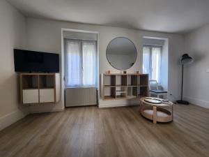 a large living room with a mirror and a table at Le cocon de Charlotte in Gray