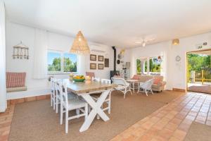 een eetkamer en woonkamer met een tafel en stoelen bij Laranjal Farm House in Moncarapacho