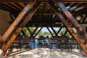 a room with wooden ceilings and tables and chairs at The Tribe Alpaca Retreat in Brăneşti