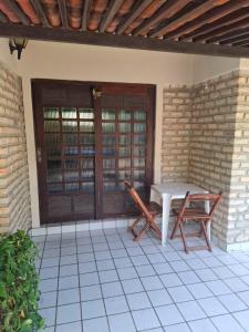 a patio with a table and two chairs at chales aguai in Natal