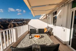 a balcony with a table with a bowl of oranges on it at Vista Calma Suite Puerto Rico in Puerto Rico de Gran Canaria +34 photos