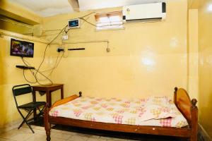 a bedroom with a bed and a chair in a room at DKS Lodge in Vellore