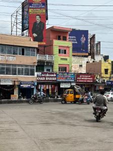a man riding a motorcycle down a city street at DKS Lodge in Vellore