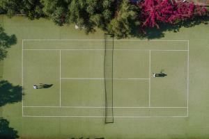 two people are laying on a tennis court at Residence Il Mirto in Palau